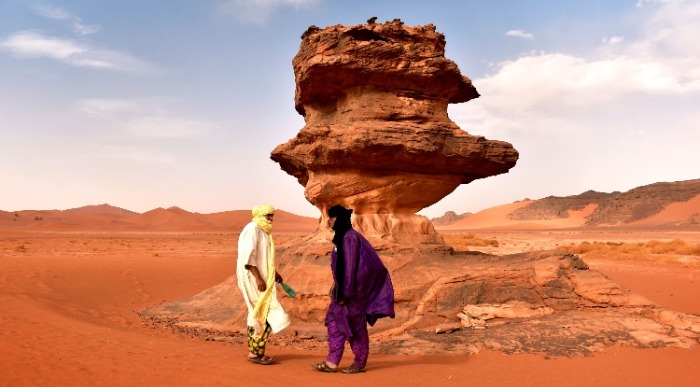 Edinstvena rdeča stožičasta skalna formacija ob dveh plemenskih moških. 