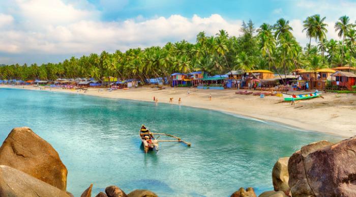 Beautiful Goa province beach in India with fishing boats and stones in the sea - Imageshutterstock_247697641