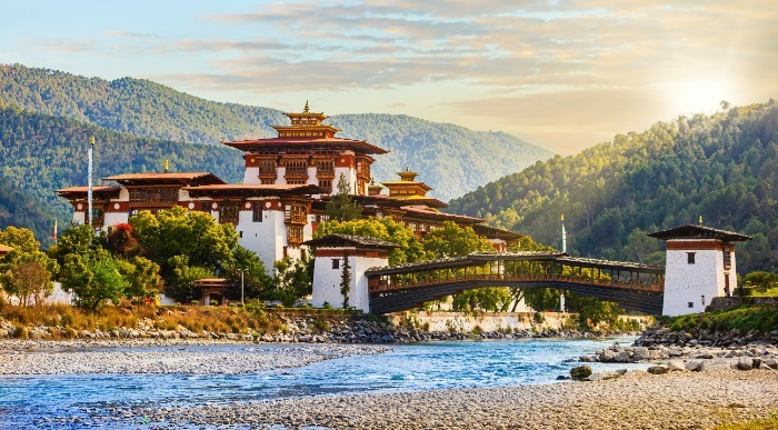 Reka mirno teče mimo azijske hiše obsijane z jutranjimi žarki.