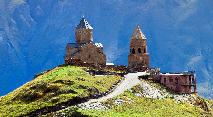 Skrivnostna cerkev  Gergeti v Gruziji obdana z mogočnimi gorami.