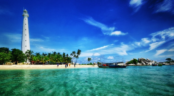 Nebeško modro nebo nad tropskim zalivom z svetilnikom na straži. 