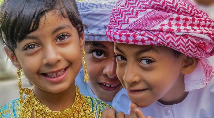Otroci v tradicionalnih oblačilih zrejo s široko odprtimi očmi.