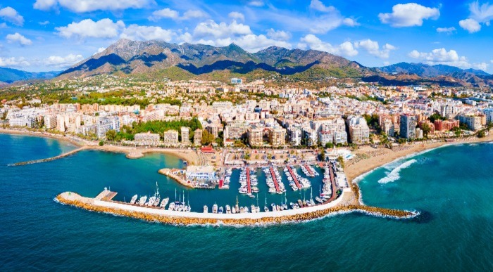 Marina v Marbelli z jadrnicami ob obalnem mestu in gorami v ozadju v Andaluziji